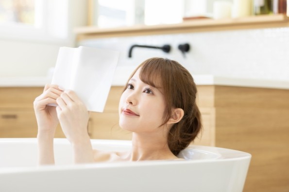 読書しながら半身浴している女性
